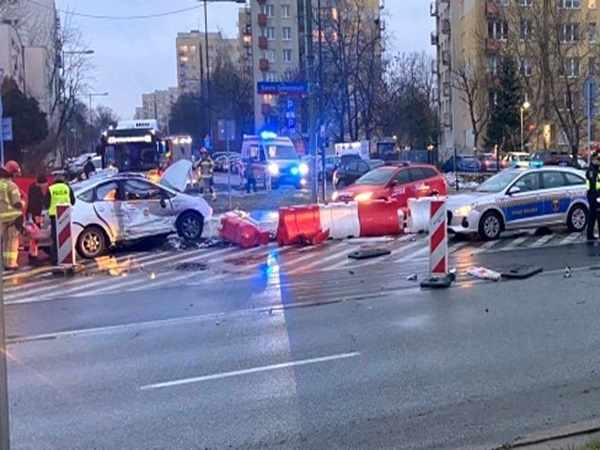 Miejsce wypadku z udziałem wielu pojazdów, uszkodzone samochody i ratownicy medyczni.