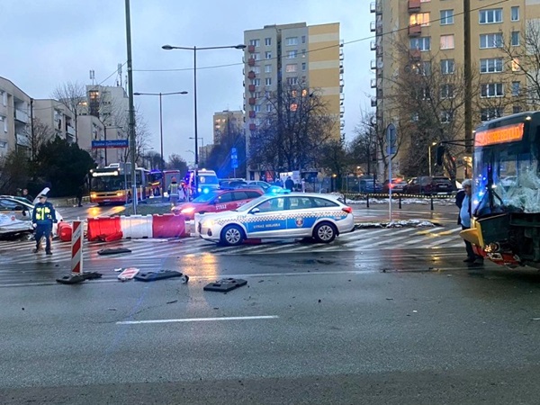 Skutki zderzenia wielu pojazdów na skrzyżowaniu w mieście, w którym brał udział autobus i radiowóz.