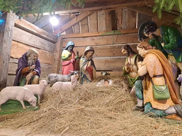 Szopka z Maryją, Józefem, Dzieciątkiem Jezus, pasterzami i zwierzętami w rustykalnej stajence.
