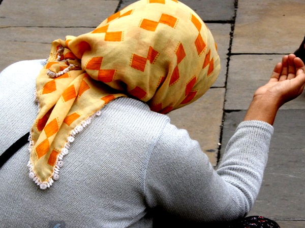 Kobieta w pomarańczowo-żółtej chuście błagająca