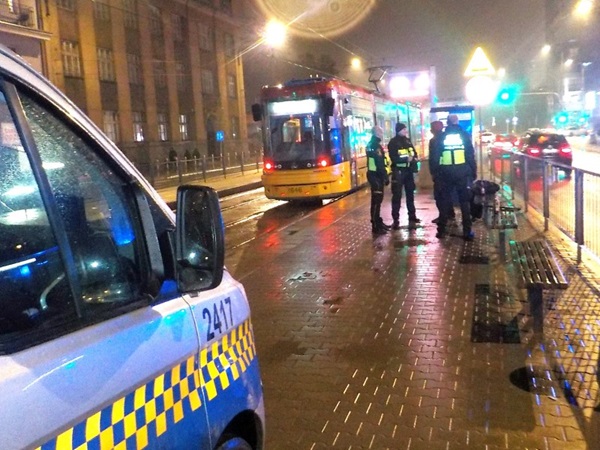 Policjanci w nocy w pobliżu przystanku tramwajowego badają incydent. Numer 2417 jest widoczny na radiowozie.