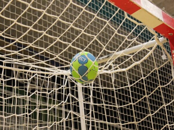 Bramka do piłki ręcznej z piłką w siatce.