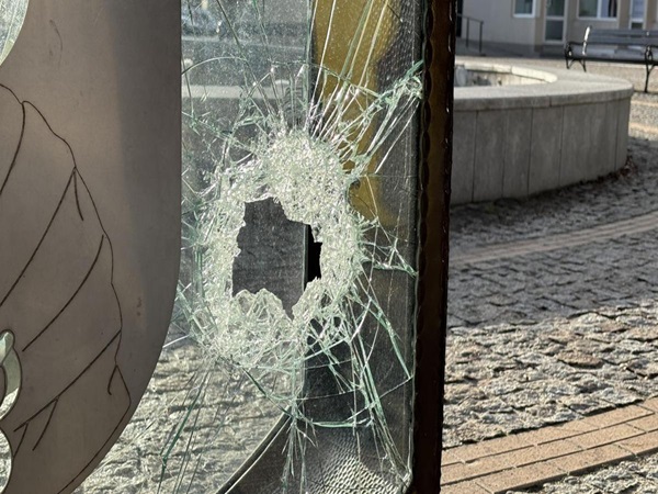 Rozbite okno z dziurą po kuli, zniszczenia w wyniku wandalizmu