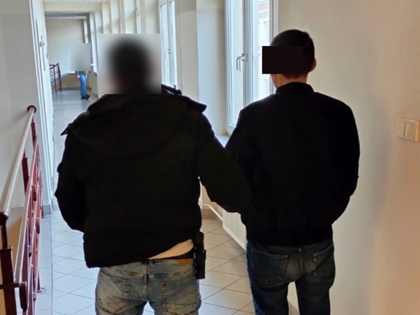 Dwóch mężczyzn w areszcie, idących korytarzem