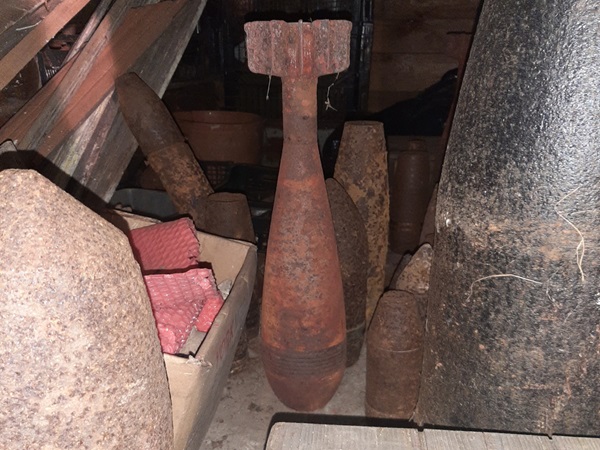 Kolekcja zardzewiałej, zabytkowej amunicji, w tym bomb i pocisków artyleryjskich.