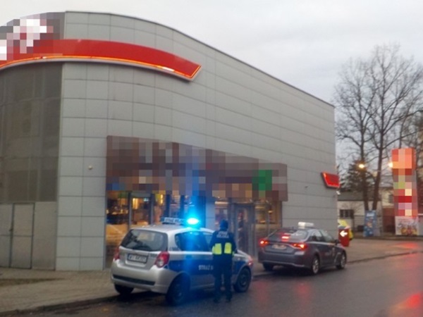 Samochody policyjne przed restauracją typu fast-food