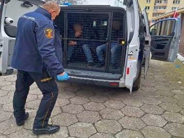 Policjant z trzema podejrzanymi w furgonetce z klatką
