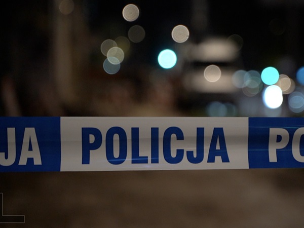 Taśma policyjna z napisem „POLICJA” na miejscu zbrodni w nocy.