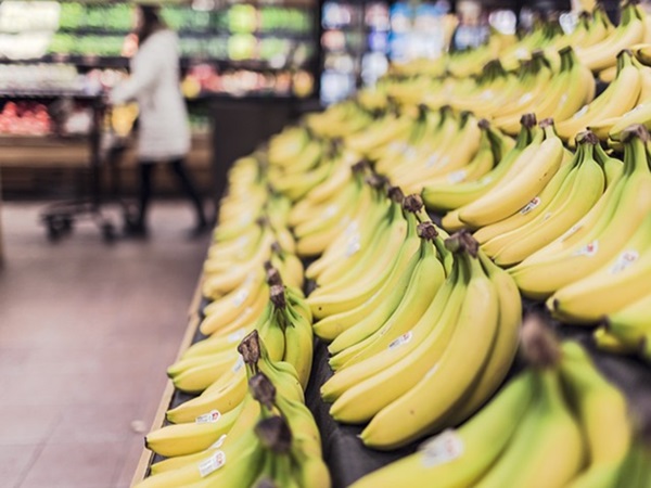 Rzędy świeżych bananów na wystawie w sklepie spożywczym