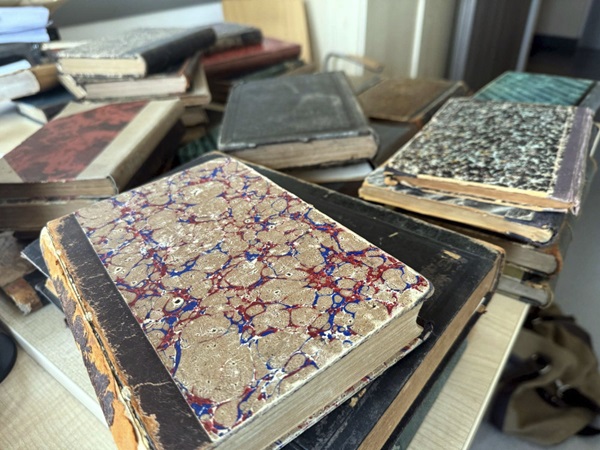 Stos starych książek z marmurkowymi okładkami