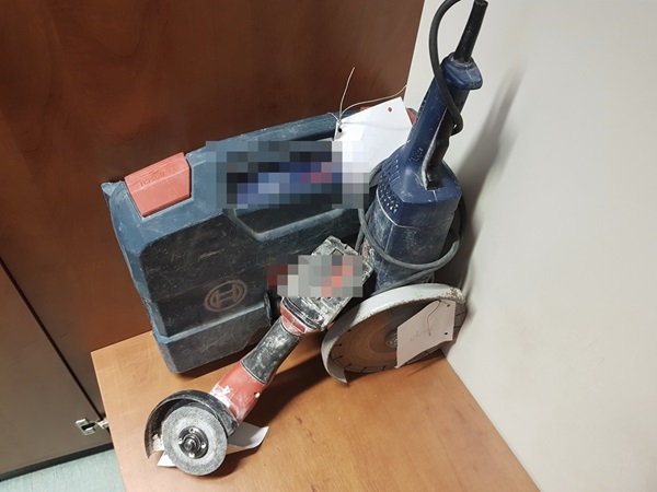 Dwie szlifierki kątowe i walizka transportowa na drewnianej powierzchni