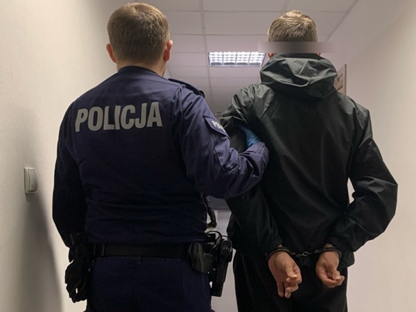 Policjant aresztujący podejrzanego, widoczne kajdanki. POLICJA.