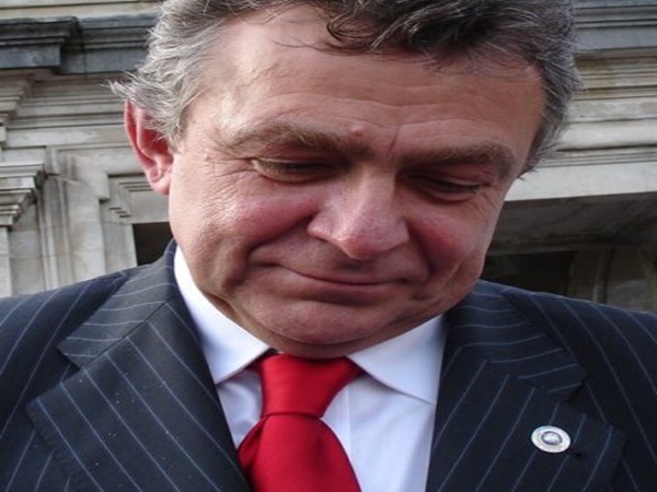 Portret zamyślonego biznesmena w garniturze w prążki i czerwonym krawacie.