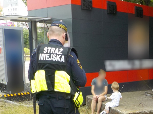 Strażnik miejski rozmawia z rodziną. Straż Miejska.