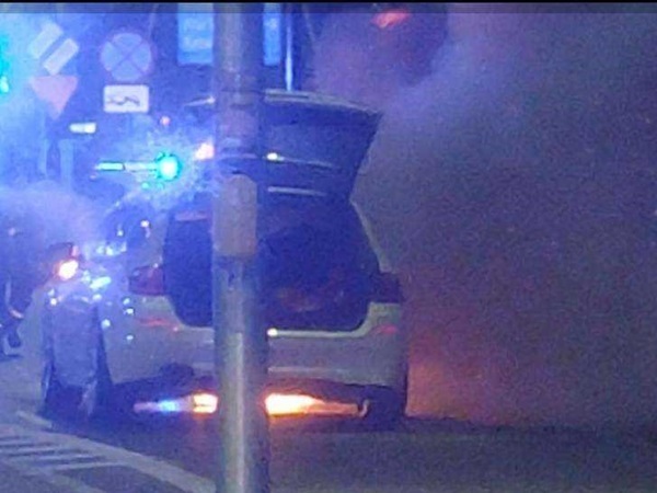 Samochód policyjny w nocy z otwartym bagażnikiem.