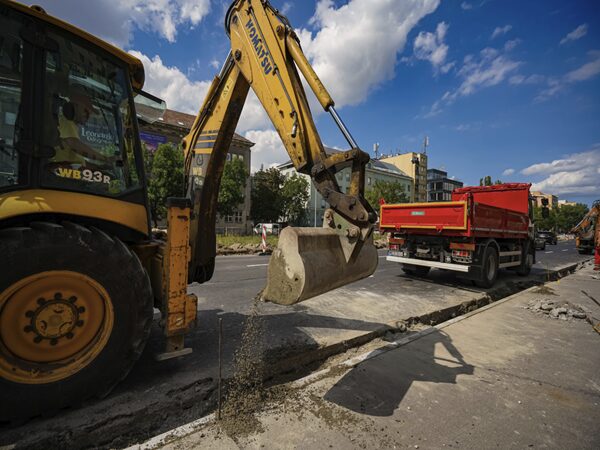 Żółta koparka usuwająca asfalt podczas budowy drogi