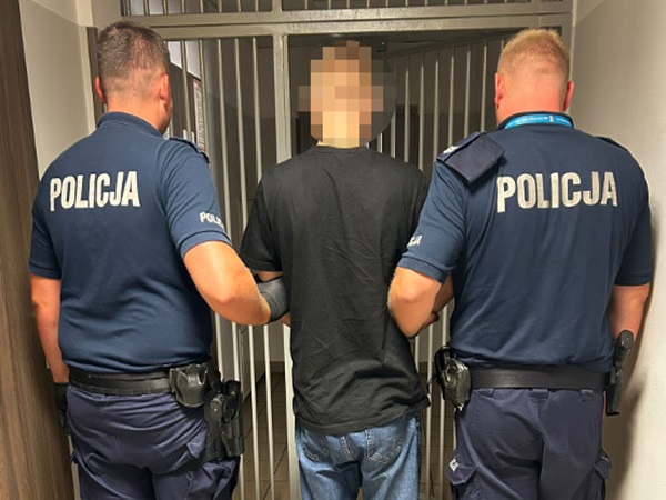 Policjanci eskortujący podejrzanego w areszcie. POLICJA