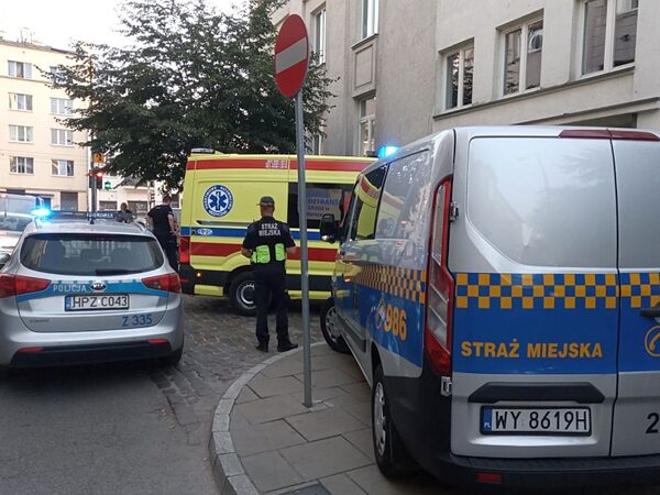 Ratownicy na miejscu zdarzenia: radiowóz, karetka pogotowia i furgonetka straży miejskiej.