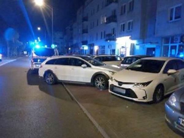 Nocny wypadek drogowy z udziałem radiowozu i uszkodzonych pojazdów.