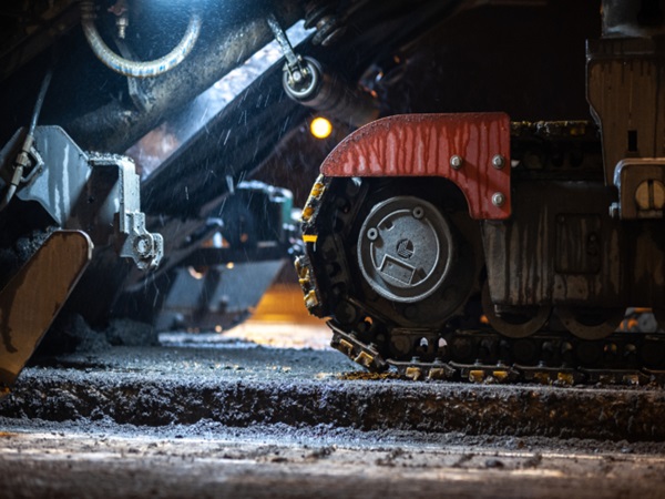 Zbliżenie na ślady maszyny układającej asfalt, układającej świeży asfalt.