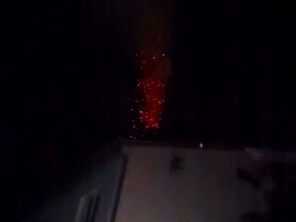 Czerwone iskry i żar wznoszący się w ciemności