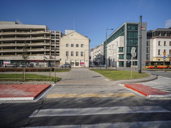 Nowoczesny widok na ulicę miasta: przejście dla pieszych, budynki i autobus.