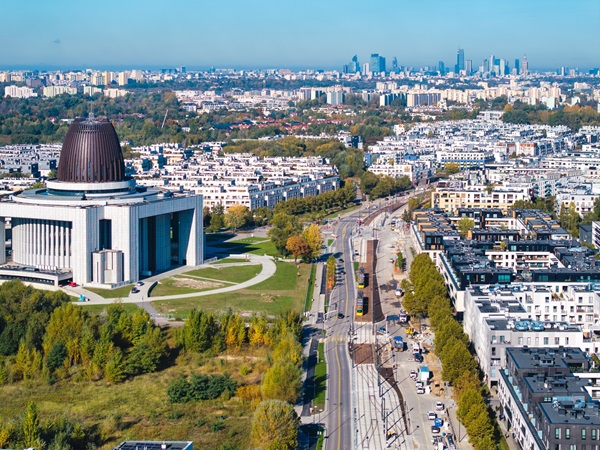 Widok z lotu ptaka na Warszawę, w Polsce, ukazujący Świątynię Baha’i i nowoczesną panoramę miasta z budową linii tramwajowych.