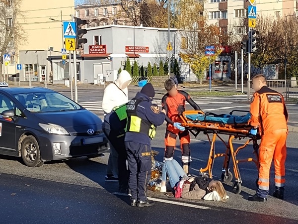 Ratownicy medyczni udzielają pomocy osobie poszkodowanej po wypadku samochodowym. Ratownicy medyczni używają noszy.