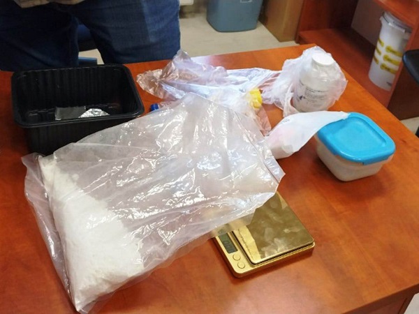 Dowody w sprawie narkotykowej: biały proszek w torebce, waga, pojemniki