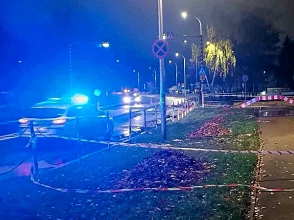 Nocna scena zbrodni z radiowozem i taśmą ostrzegawczą