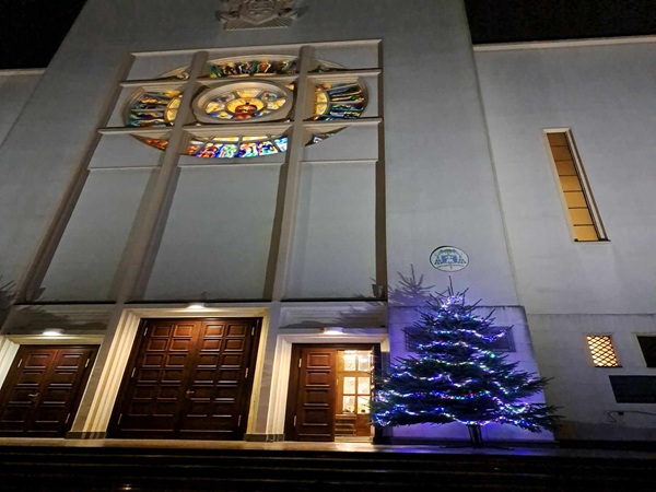 Nocny widok oświetlonego kościoła z choinką