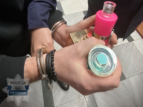 Zbliżenie na skute ręce trzymające podrobione perfumy. Śledztwo policyjne.