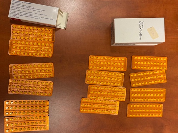 Wiele blistrów pomarańczowych tabletek i pudełko Samsung Galaxy S III.