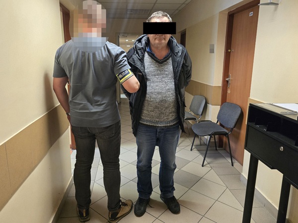 Policjant eskortujący podejrzanego korytarzem