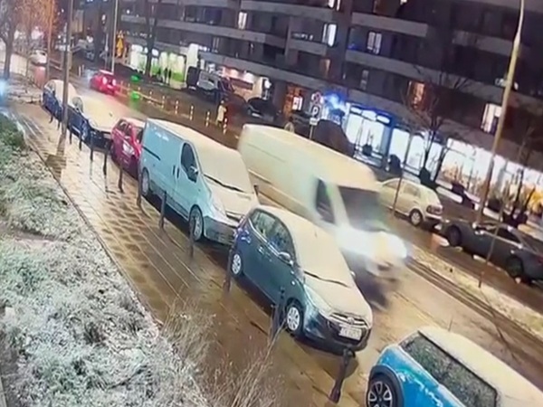 Pokryte śniegiem samochody zaparkowane nocą na ulicy miasta.