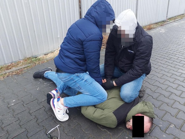 Policjanci obezwładniają podejrzanego na ziemi