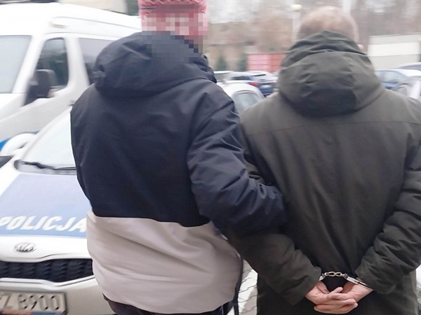 Dwóch mężczyzn w kajdankach, aresztowanych przez policję.