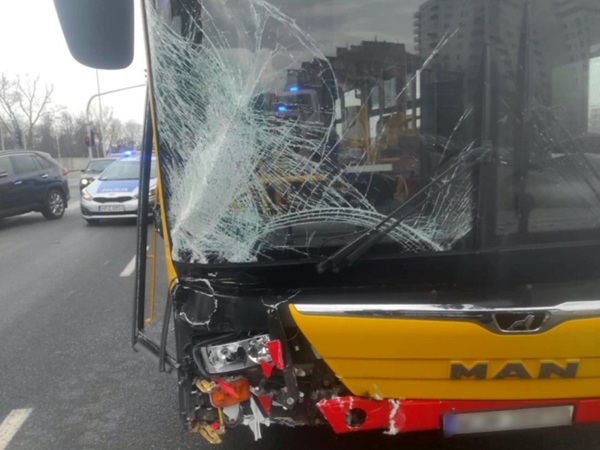 Uszkodzona przednia szyba autobusu MAN po wypadku. Przód autobusu wykazuje znaczne uszkodzenia od uderzenia.