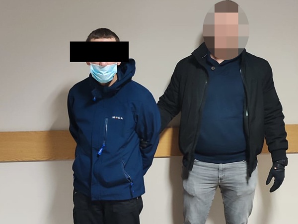 Dwóch mężczyzn w areszcie, jeden z nich miał na twarzy maskę.