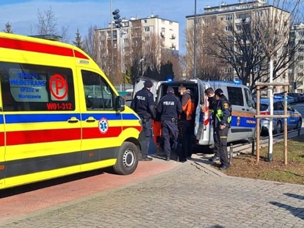 Ratownicy na miejscu wypadku z karetką pogotowia i radiowozami. W01-312