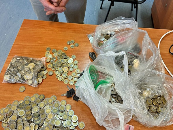 Kilka worków z monetami i kluczami na drewnianym stole.