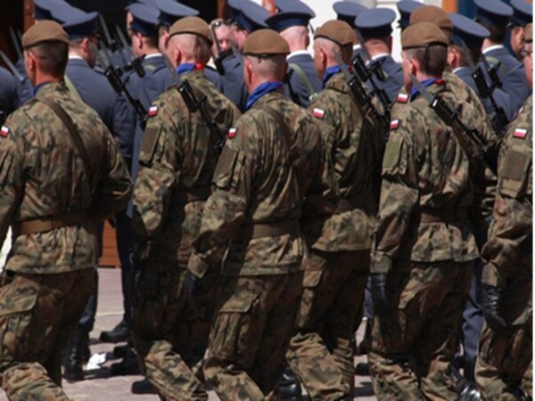 Polscy żołnierze w mundurach maskujących maszerują w szyku.