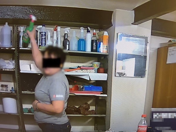 Kobieta czyści półki w sklepie za pomocą spryskiwacza