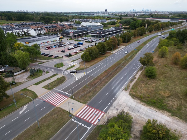 Widok z lotu ptaka na skrzyżowanie podmiejskie z centrum handlowym i jezdnią.