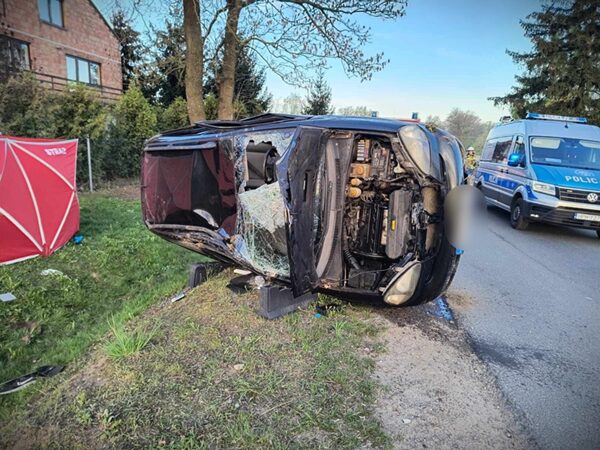 Wywrócony samochód po wypadku, na miejscu policja i służby ratunkowe