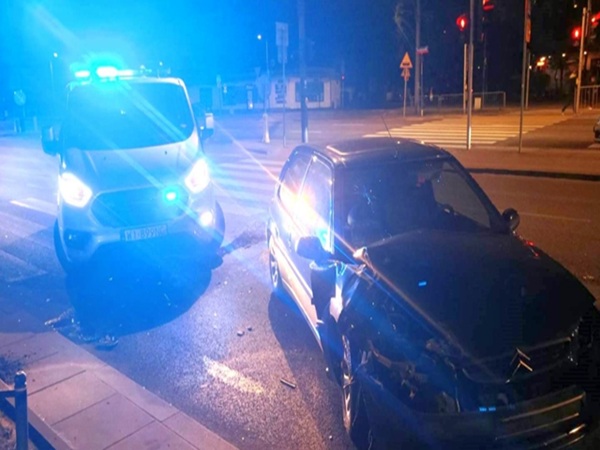 Uszkodzony samochód w nocy, obecny pojazd policyjny. Miejsce wypadku.