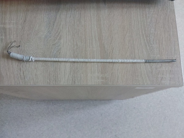 Zbliżenie cienkiego, szarego metalowego pręta owiniętego białą taśmą, prawdopodobnie dowód kradzieży.