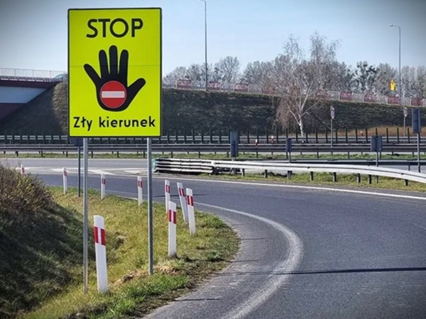 Znak stop po polsku: „Zły kierunek”. Znak drogowy przy zjeździe z autostrady.