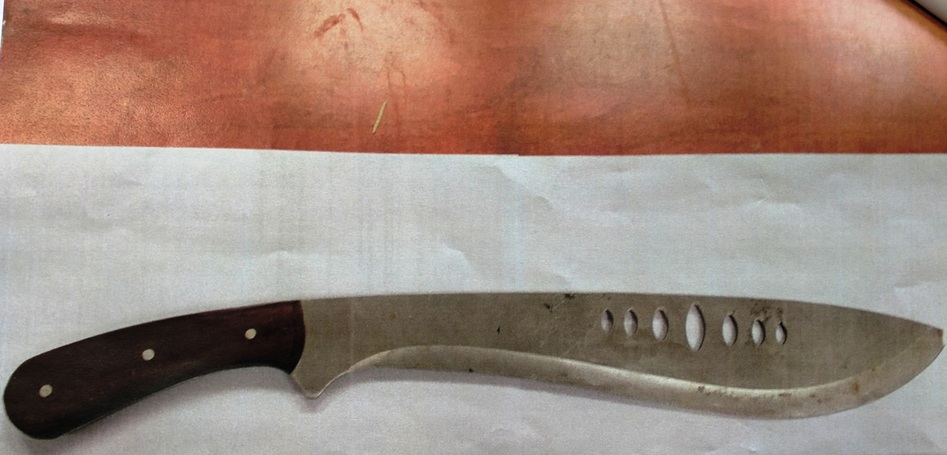 Zbliżenie dużej, lekko używanej maczety z ciemnobrązową drewnianą rękojeścią.