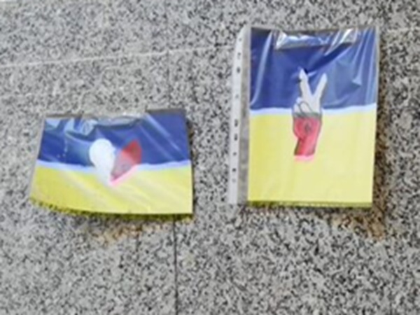 Dwie małe flagi ukraińskie; jedna z nich przedstawia znak pokoju.